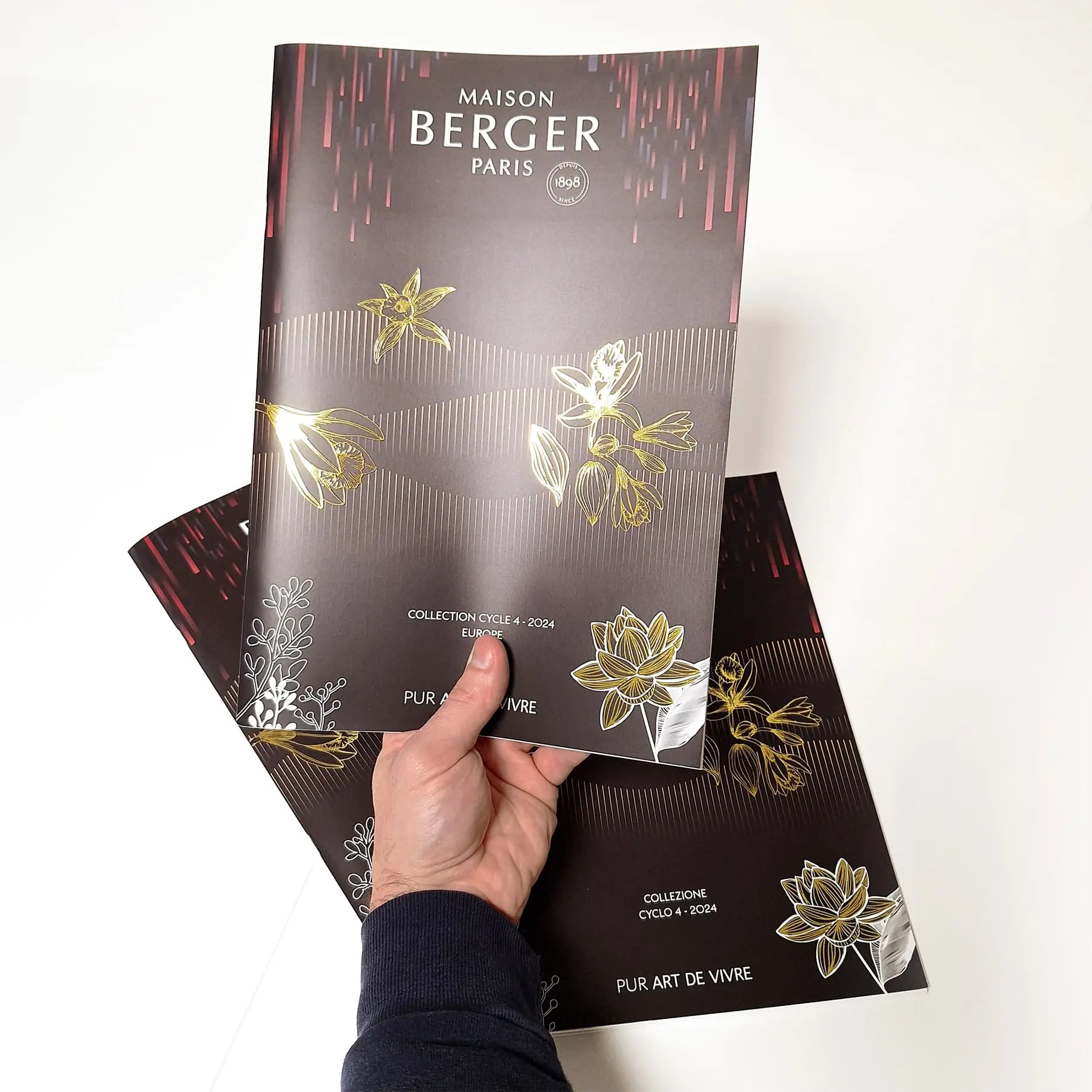 Magazine de parfum avec dorure tenu en main